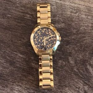 Woman’s Coach gold with black background